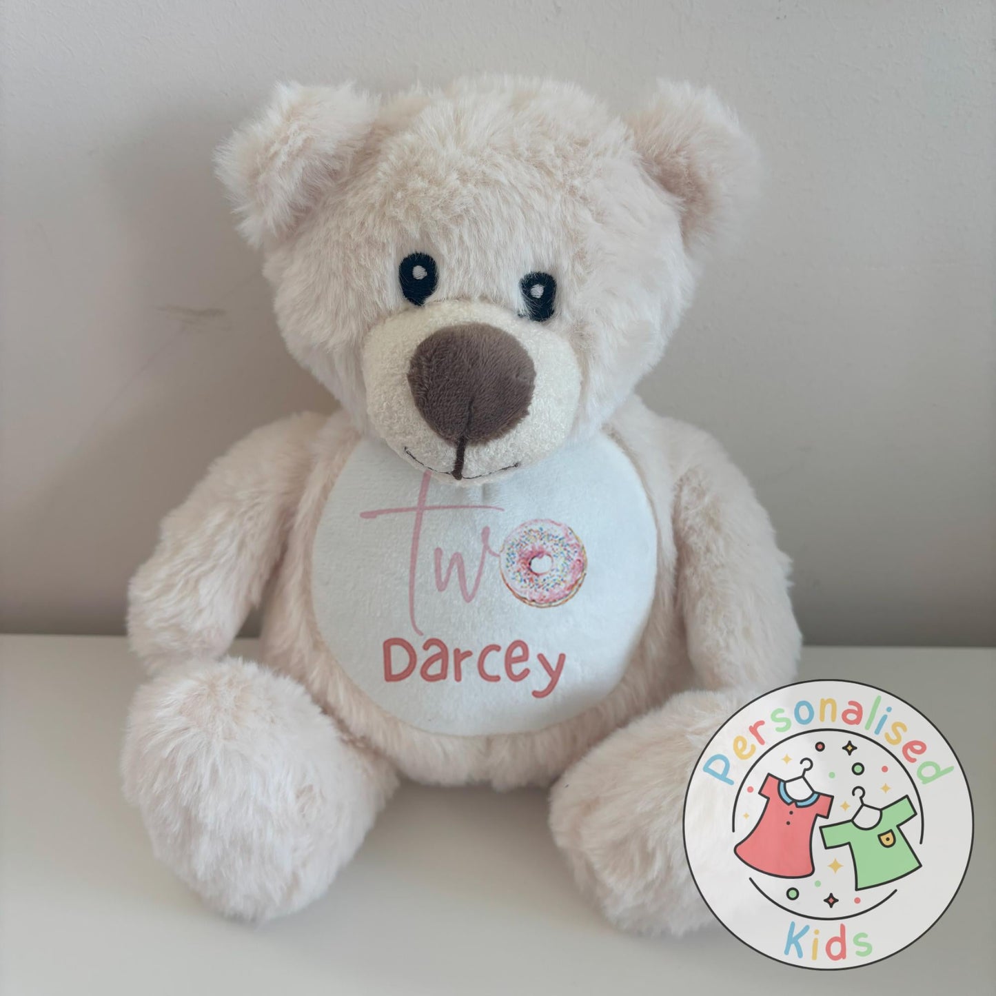 Celebrate their special day with this adorable personalised birthday teddy bear! Featuring a fun sprinkle donut design with your child’s age and name, this cuddly keepsake makes the perfect birthday gift, cake smash prop, or memory bear to treasure for years to come.