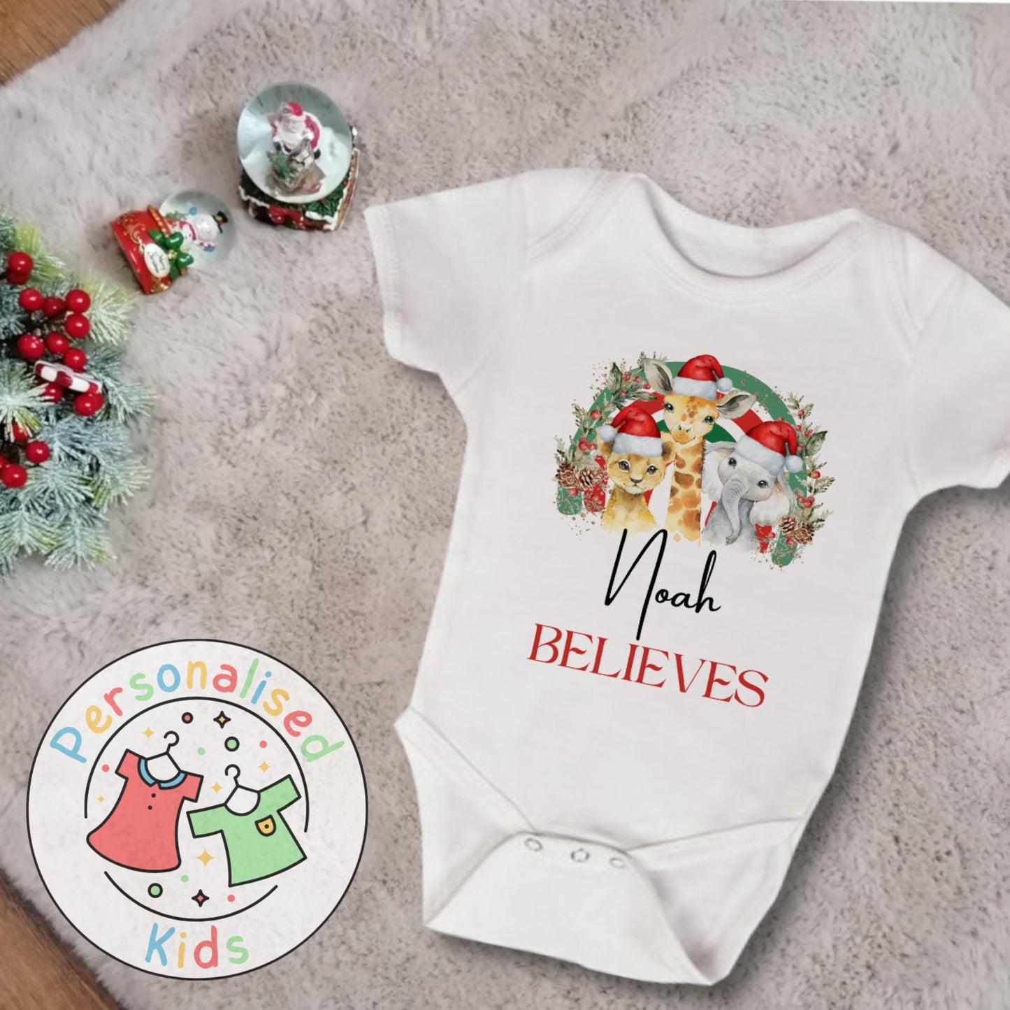 Make this Christmas even more magical with our Personalised Christmas onesie pj – perfect for the whole family! These white cotton bay onsies feature an adorable festive safari animal design, complete with your chosen name and the word &quot;BELIEVES&quot; printed underneath in bold red. Whether you&#39;re matching on Christmas morning, heading to a festive event, or capturing the perfect holiday photo, these cosy onsies are the perfect touch of personalised Christmas cheer.