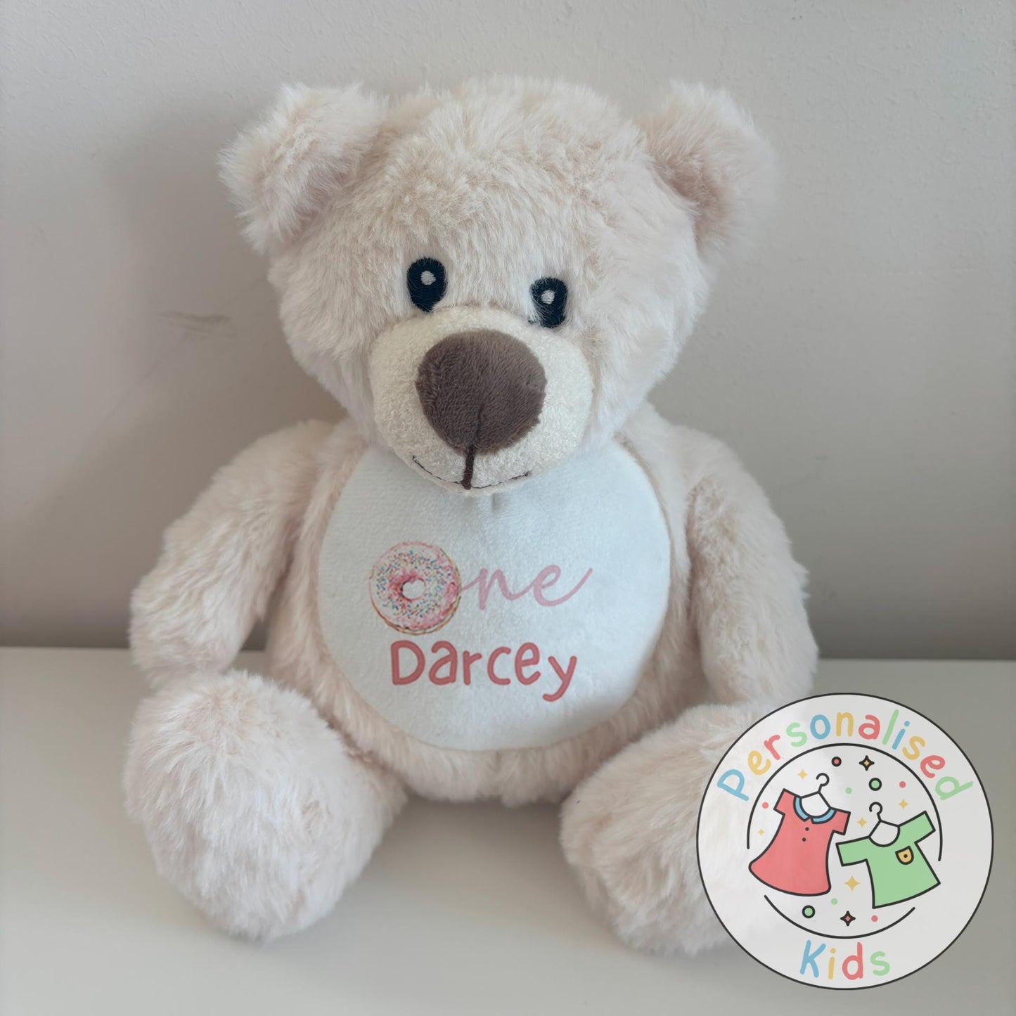 Celebrate your little one’s milestone with this adorable personalised donut teddy bear. Featuring the word “One” with a sprinkle donut design and your child’s name printed underneath, this cuddly bear makes the perfect keepsake gift for birthdays, baby showers, or simply as a special surprise.