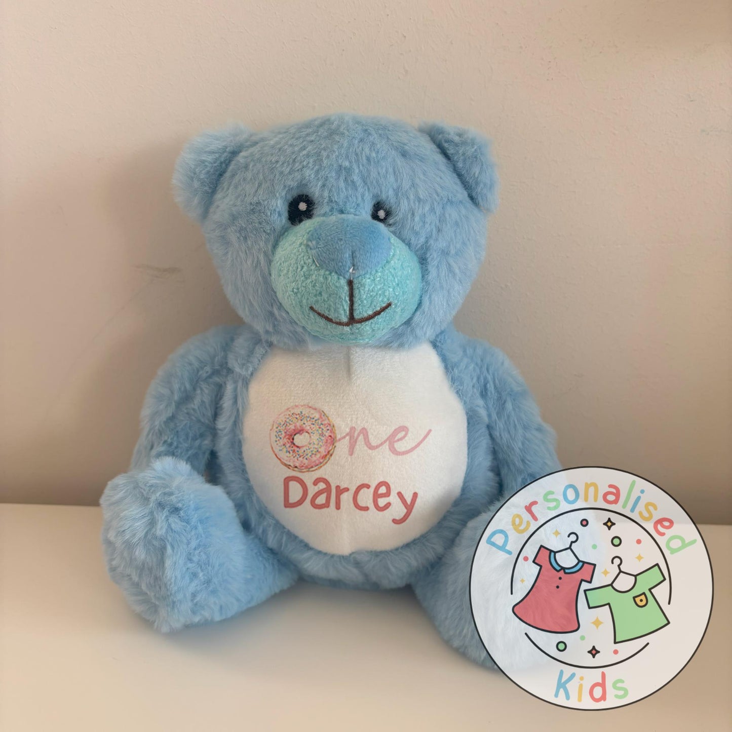 Celebrate your little one’s milestone with this adorable personalised donut teddy bear. Featuring the word “One” with a sprinkle donut design and your child’s name printed underneath, this cuddly bear makes the perfect keepsake gift for birthdays, baby showers, or simply as a special surprise.