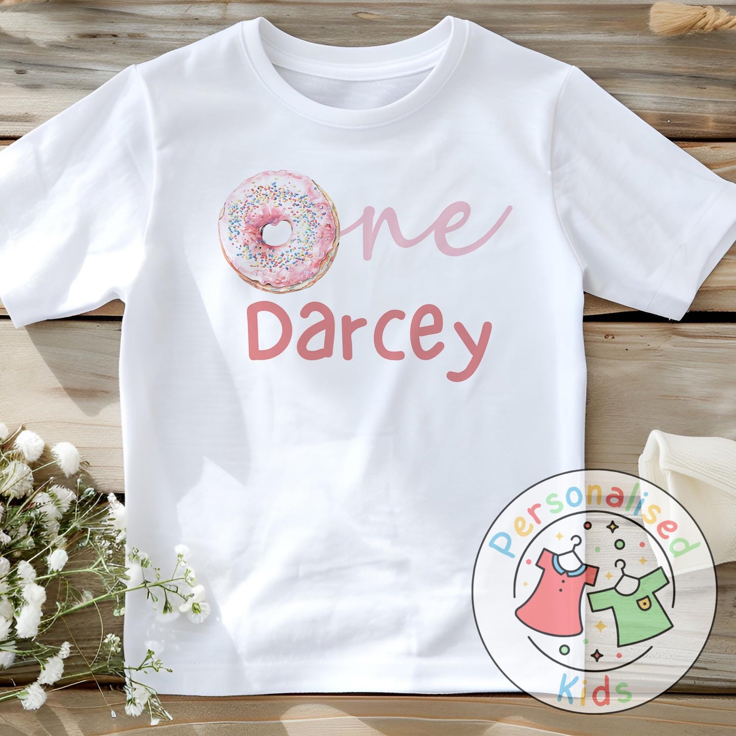 Make their first birthday extra sweet with this adorable personalised donut birthday outfit. Featuring the word “One” with a colourful sprinkle donut design in place of the “O”, and your child’s name personalised underneath, this outfit is perfect for birthday celebrations, cake smash photos, or as a keepsake to treasure.
