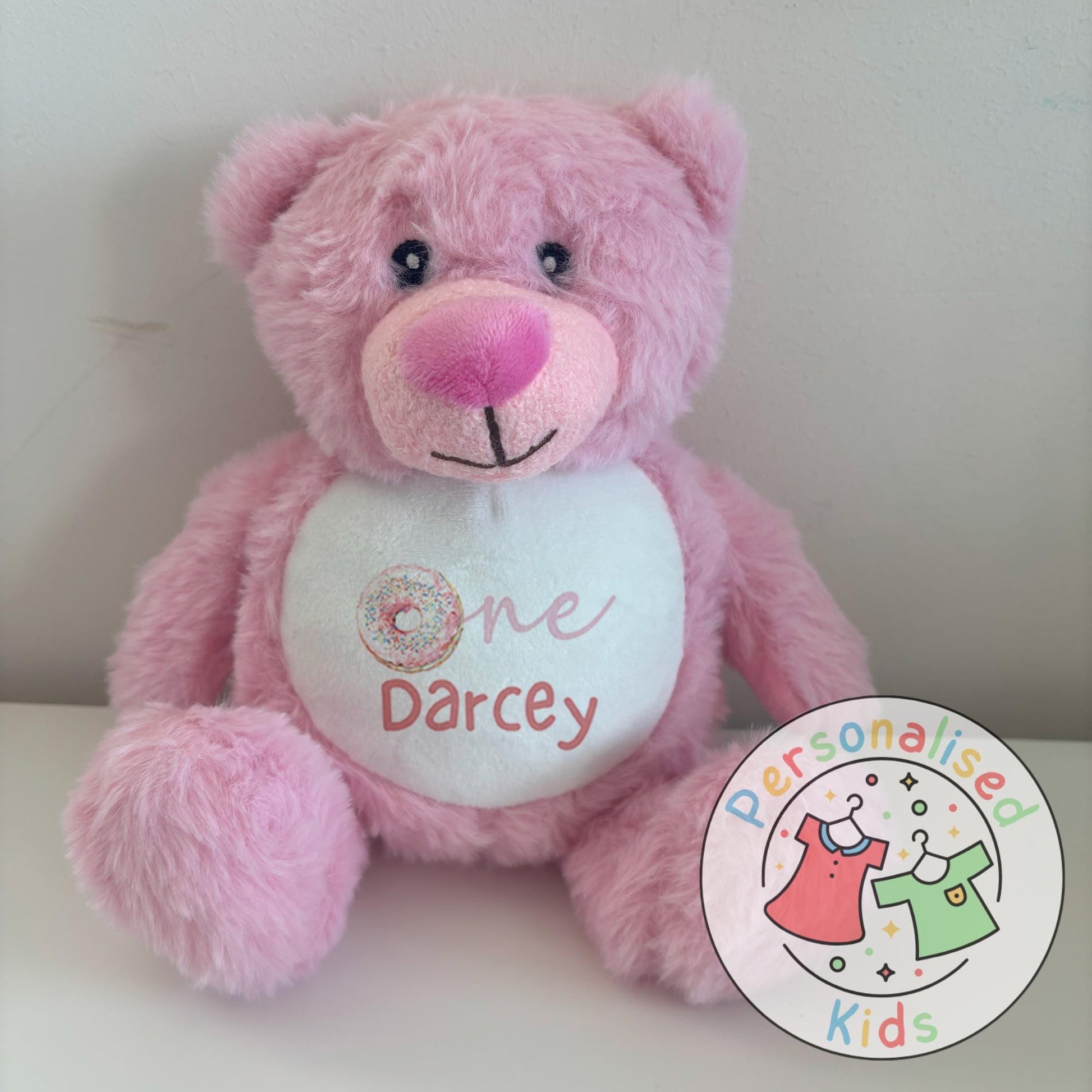 Celebrate your little one’s milestone with this adorable personalised donut teddy bear. Featuring the word “One” with a sprinkle donut design and your child’s name printed underneath, this cuddly bear makes the perfect keepsake gift for birthdays, baby showers, or simply as a special surprise.