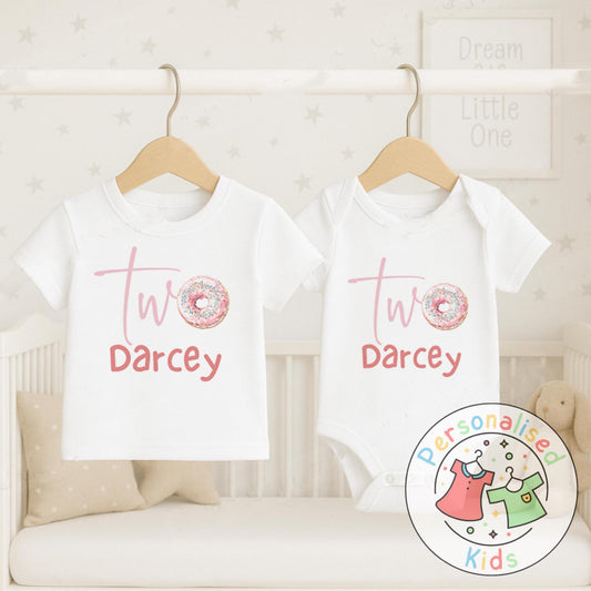 Make their 2nd birthday even sweeter with this adorable personalised donut birthday outfit! Featuring the word “Two” with a sprinkle donut design and your child’s name underneath, this cute top or baby grow is the perfect choice for a birthday celebration, cake smash, or as a special keepsake gift.