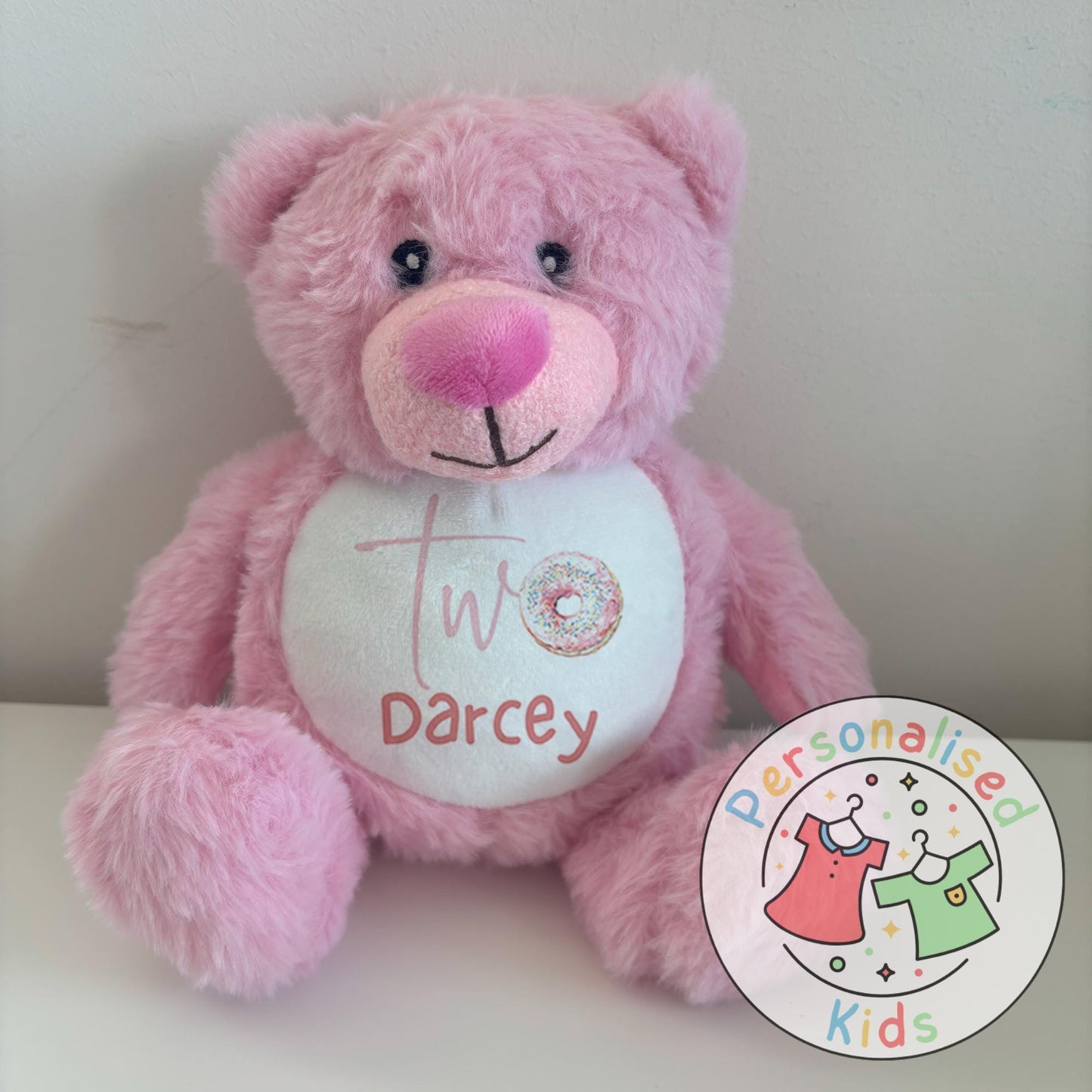 Celebrate their special day with this adorable personalised birthday teddy bear! Featuring a fun sprinkle donut design with your child’s age and name, this cuddly keepsake makes the perfect birthday gift, cake smash prop, or memory bear to treasure for years to come.