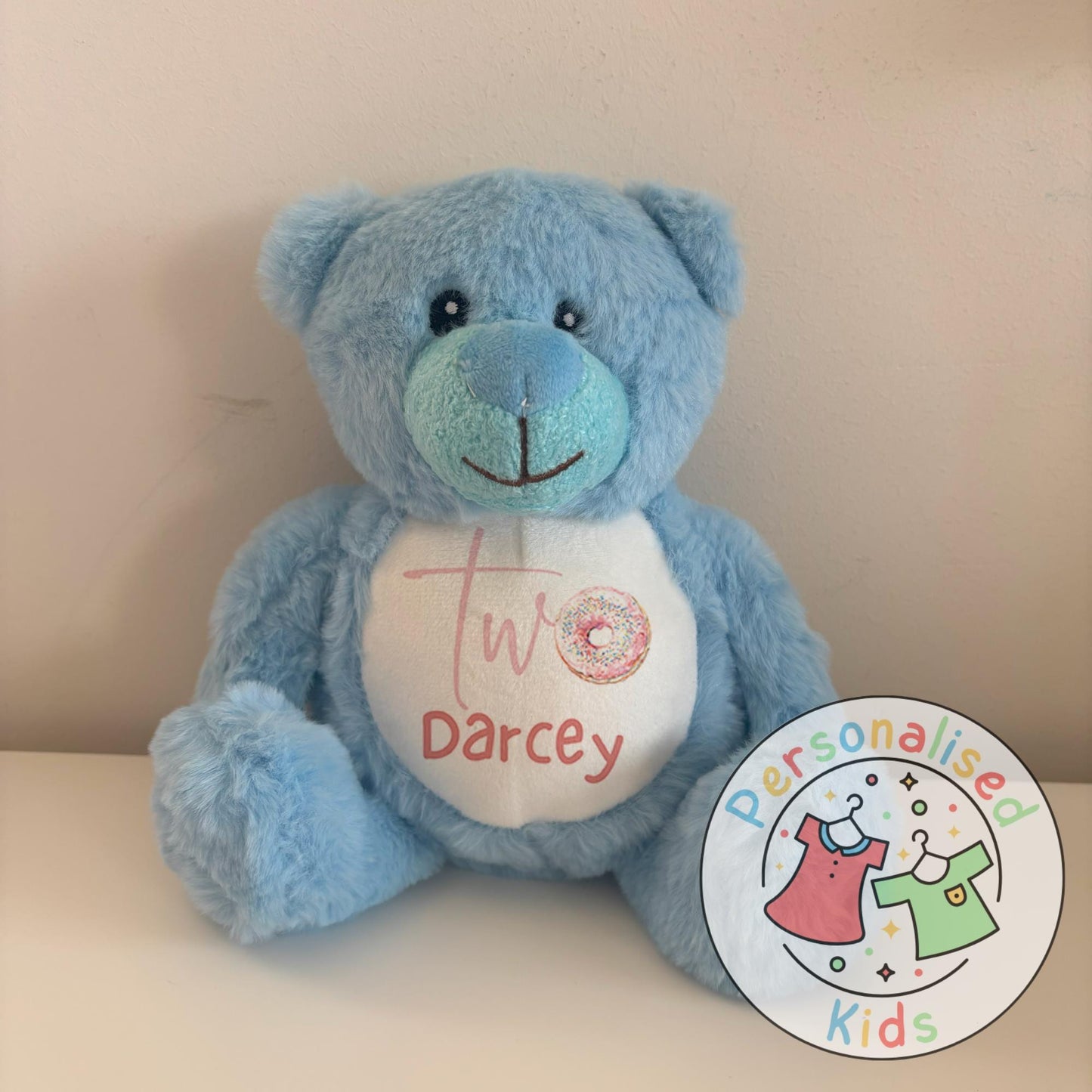 Celebrate their special day with this adorable personalised birthday teddy bear! Featuring a fun sprinkle donut design with your child’s age and name, this cuddly keepsake makes the perfect birthday gift, cake smash prop, or memory bear to treasure for years to come.